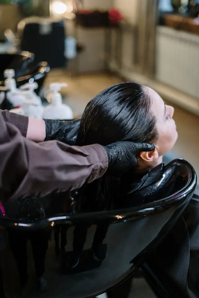 A hairstylist washing a girls hair before getting a haircut